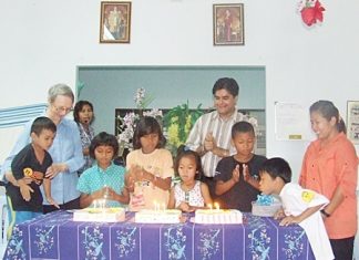 Sister Joan and Tony cheer as the birthday children blow out the candles on the birthday cakes.